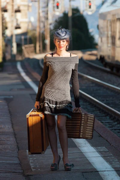 Mujer con equipaje vintage en la estación de tren — Foto de Stock