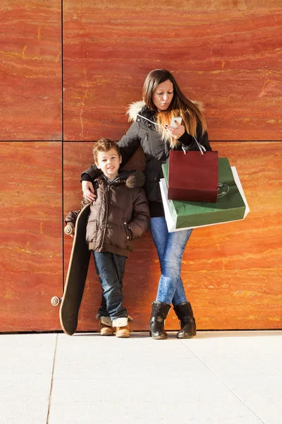 Dívka s dítě čeká s obchod tašky — Stock fotografie