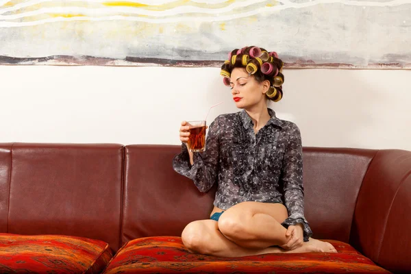 Girl drinking a drink on the couch — Stock Photo, Image