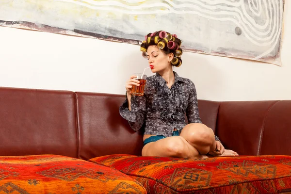 Girl drinking a drink on the couch — Stock Photo, Image