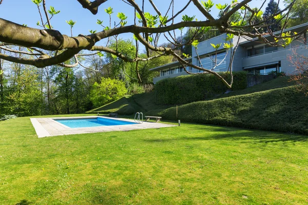Вне современного дома в летнее время, бассейн — стоковое фото