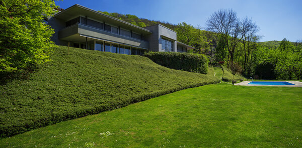 Вне современного дома в летнее время, бассейн
