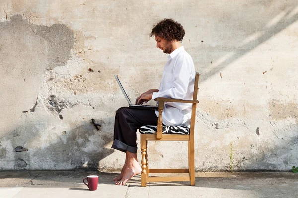 Man in buitenkant met een laptop — Stockfoto