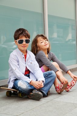 Kardeşim bir duvarın önünde oturan kız kardeşi