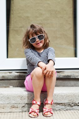 Kapının önünde oturan kız