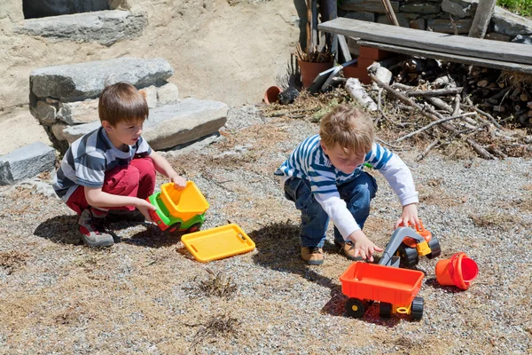 Dos chicos jugando al aire libre con juguetes — Foto de Stock