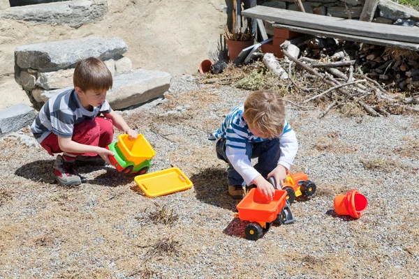 Two boys playing outdoor with toys — Stock Photo, Image