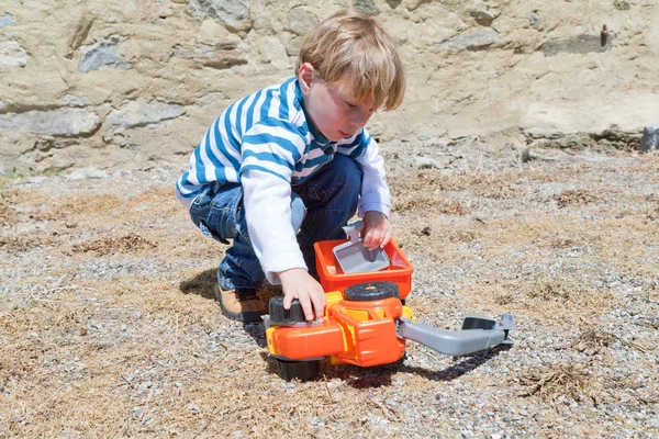 Pequeño niño jugando con juguete de plástico — Foto de Stock