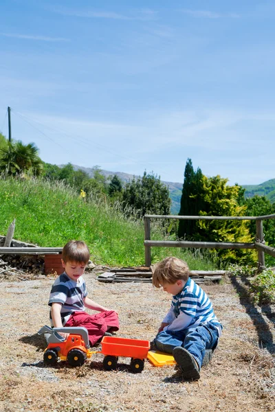 Two boys playing outdoor with toys — Stock Photo, Image