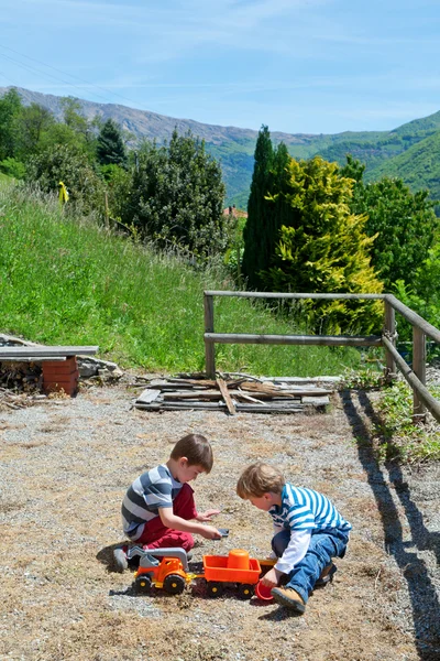 Two boys playing outdoor with toys — Stock Photo, Image