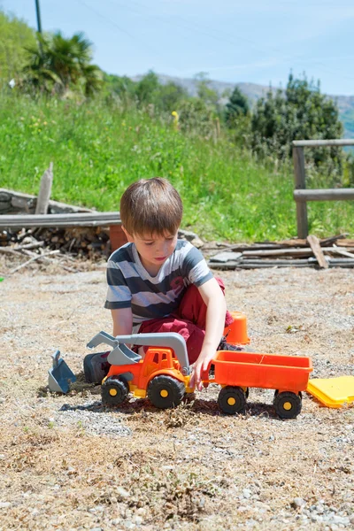 Ragazzino che gioca con auto giocattolo di plastica — Foto Stock