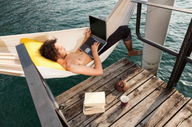 Gölde dizüstü bilgisayar ile genç adam