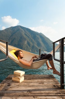 Gölde dizüstü bilgisayar ile genç adam