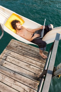 Gölde dizüstü bilgisayar ile genç adam