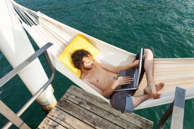 Gölde dizüstü bilgisayar ile genç adam