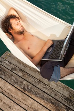 young man with laptop on the dock