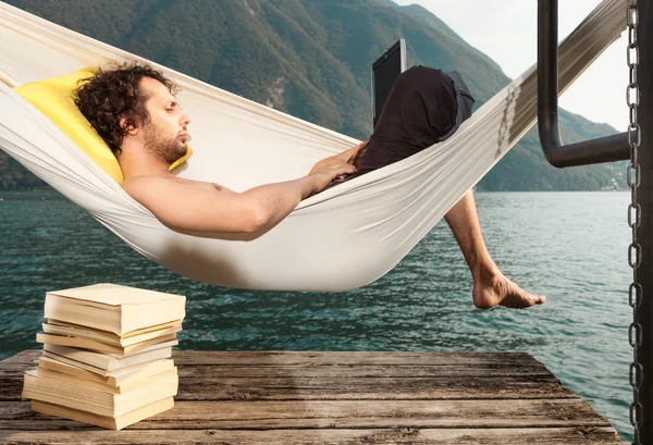 Junger Mann mit Laptop am See — Stockfoto