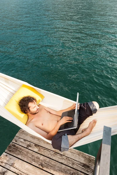 Joven con portátil en el lago —  Fotos de Stock