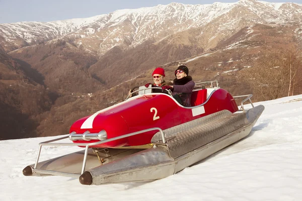 Sweet and weird couple surfing on a pedalos in winter time ( not — Stock Photo, Image