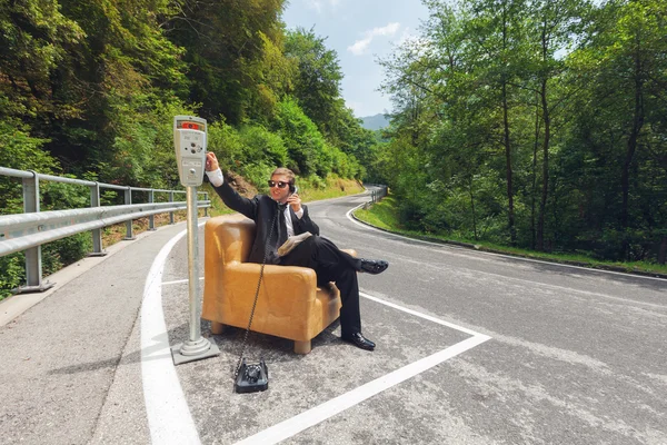 Empresário sentado em poltrona no meio da estrada — Fotografia de Stock