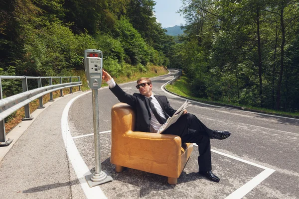 Businessman sitting on armchair in the middle of the road — Stock Photo, Image
