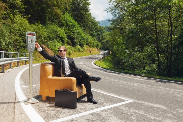 Empresário sentado em poltrona no meio da estrada — Fotografia de Stock