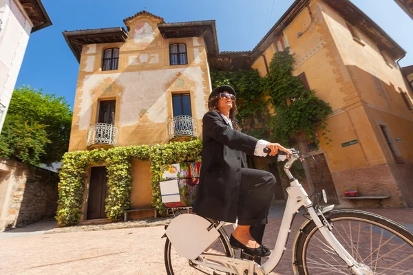 Mulher de bicicleta pelas ruas do país — Fotografia de Stock