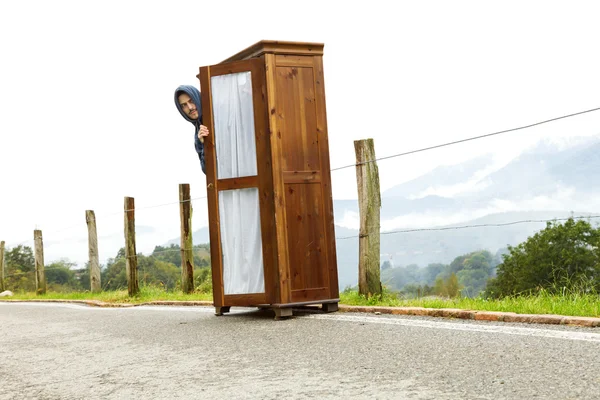 Orang dalam situasi yang aneh, melihat keluar dari lemari di tengah — Stok Foto