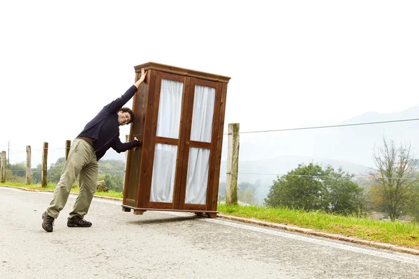 Man moves wardrobe, is making a move — Stok fotoğraf