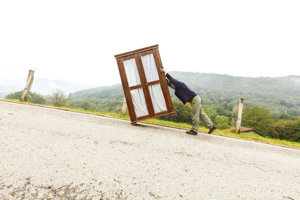 Людина рухає шафи, робить крок — стокове фото