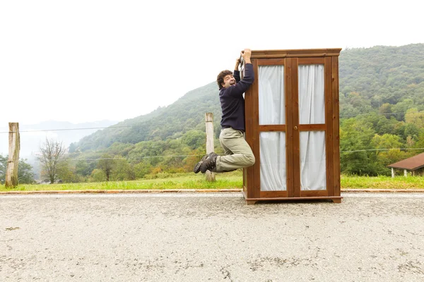 Man moves wardrobe, is making a move — Stock Photo, Image