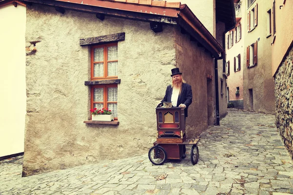 Red hair and beard elegant man playing his cart organ around — Stock Photo, Image