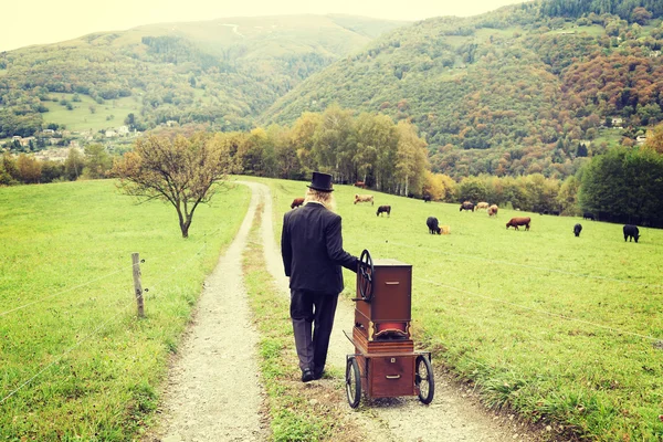 Red hair and beard elegant man playing his cart organ around — Stock Photo, Image