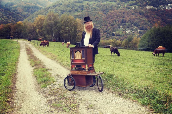 Cabelo vermelho e barba homem elegante tocando seu órgão carrinho ao redor — Fotografia de Stock