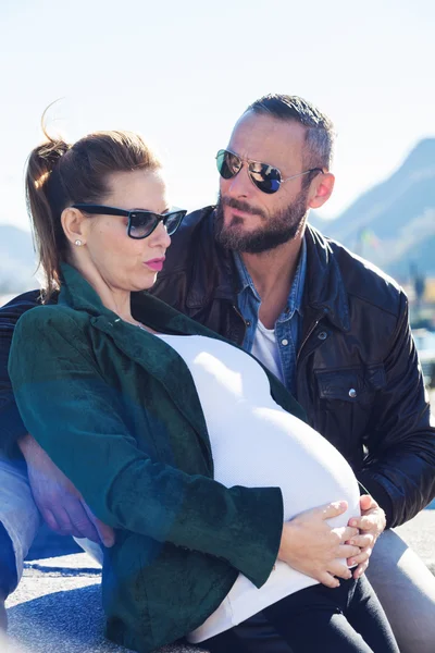 Счастливая беременная пара на открытом воздухе — стоковое фото