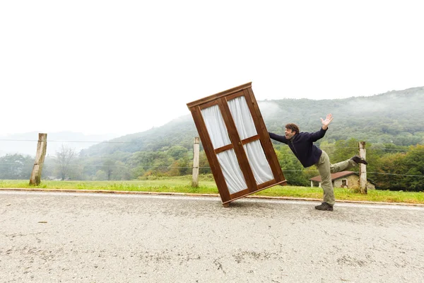 Man moves wardrobe, is making a move Stock Image