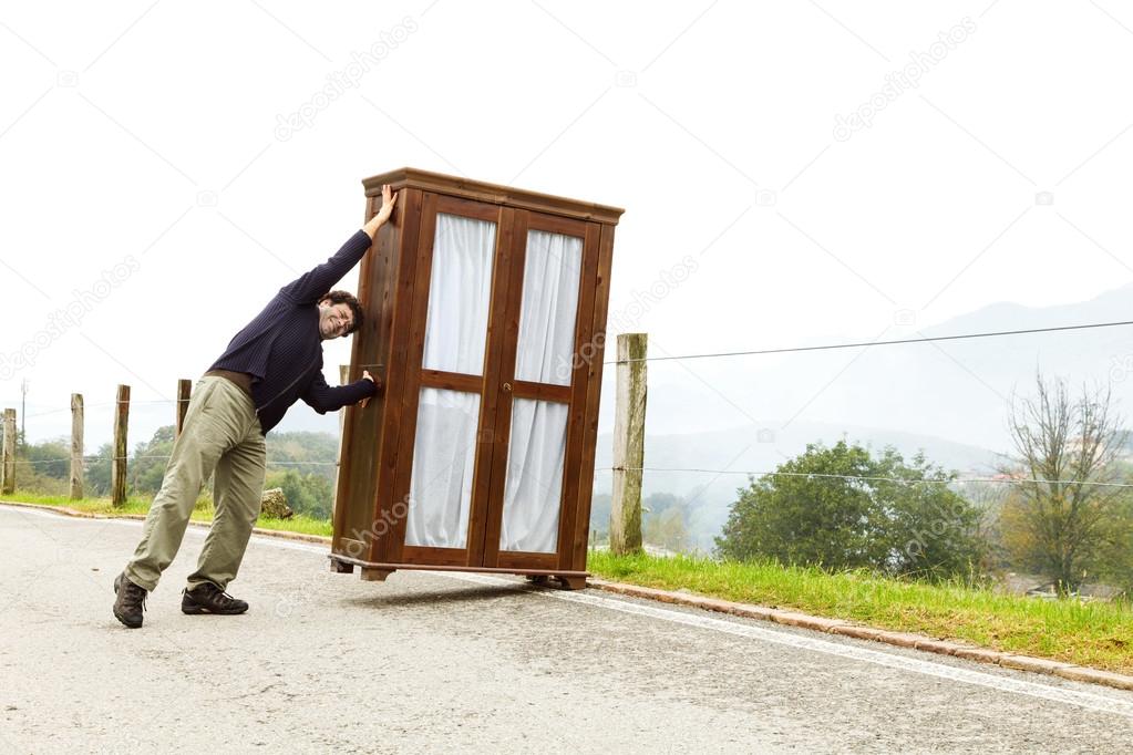 man moves wardrobe, is making a move