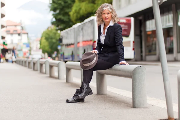 Woman sitting at the roadside — Stock Photo, Image