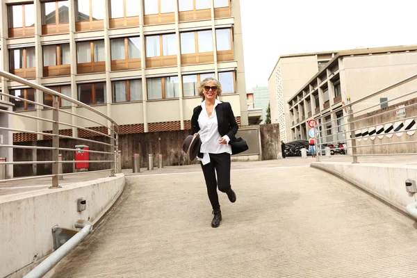 Mature businesswoman runs for the city — Stock Photo, Image