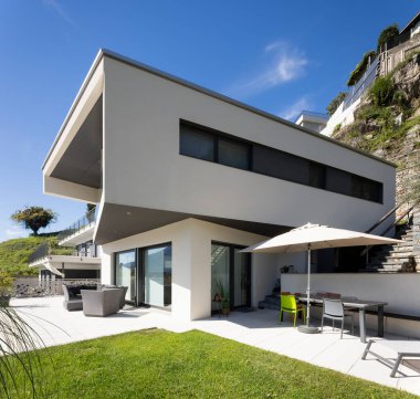 Terası ve oturma odası olan modern bir evin ayrıntıları. Mavi gökyüzü güneşli. Güzel yer.