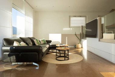 Özel bir evde, oturma odasının içinde. Direk yandan ateş edilmiş. Televizyonun önünde büyük siyah bir kanepe var..