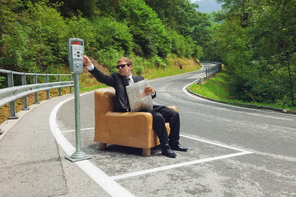 Businessman sitting on armchair in the middle of the road — Stock Photo, Image