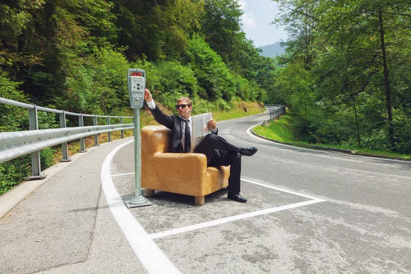 Empresário sentado em poltrona no meio da estrada — Fotografia de Stock