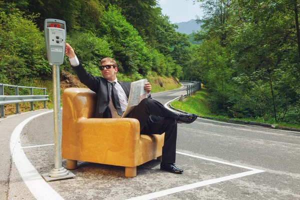 Businessman sitting on armchair in the middle of the road — Stock Photo, Image