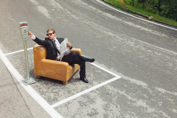 Podnikatel, sedící na křesle uprostřed silnice — Stock fotografie