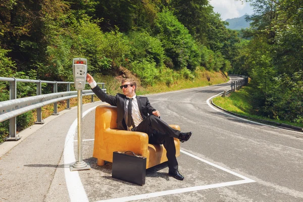 Empresário sentado em poltrona no meio da estrada — Fotografia de Stock