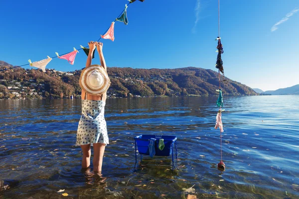 Waman, věšela prádlo u jezera — Stock fotografie