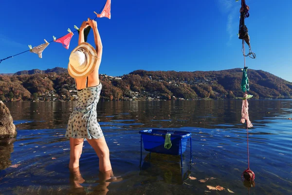 Waman, colgando ropa junto al lago — Foto de Stock