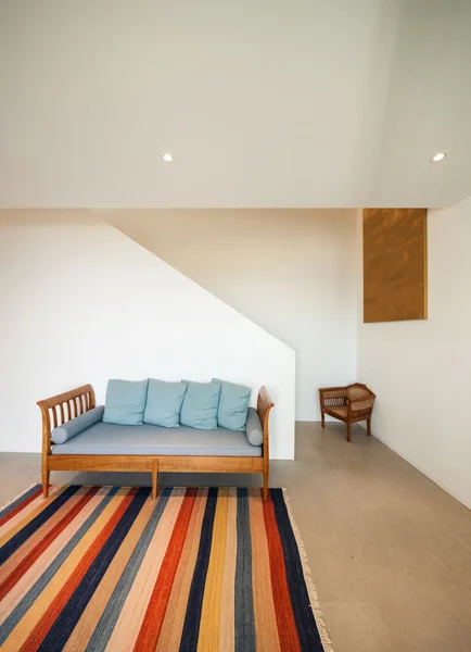Зал с диваном и полосатым ковром — стоковое фото