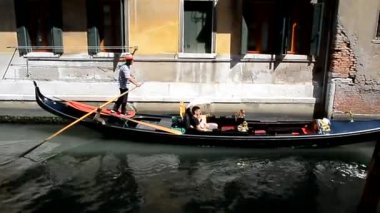 Gondolcu turistler bir gondol dar bir kanal içinde taşıma